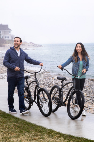 Couple walks black beach cruiser bikes, Lake Michigan