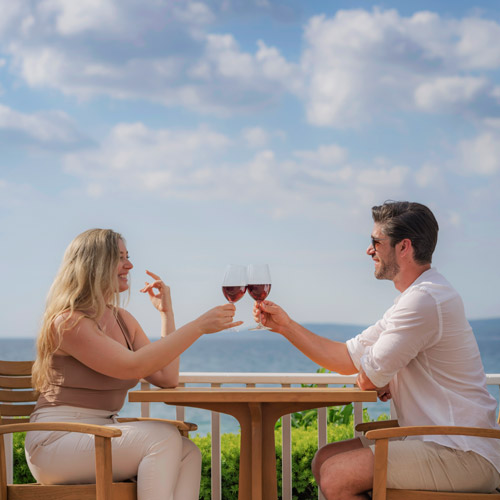 Couple toasts with red wine at Lake Michigan, Inn at Bay Harbor