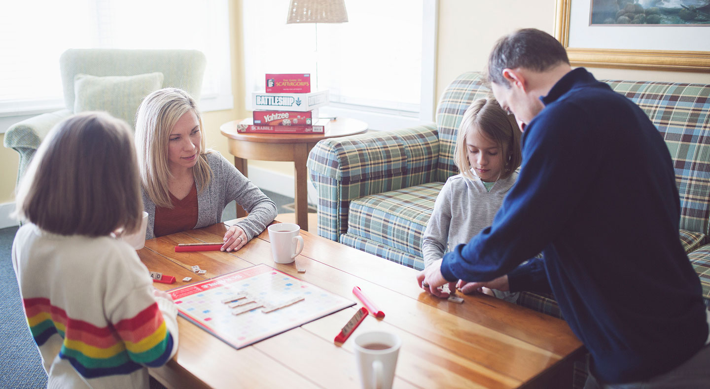 family playing board games at Crooked Tree Cottages