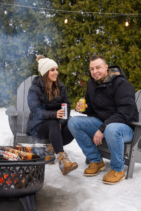 Couple enjoys drinks by outdoor firepits in winter