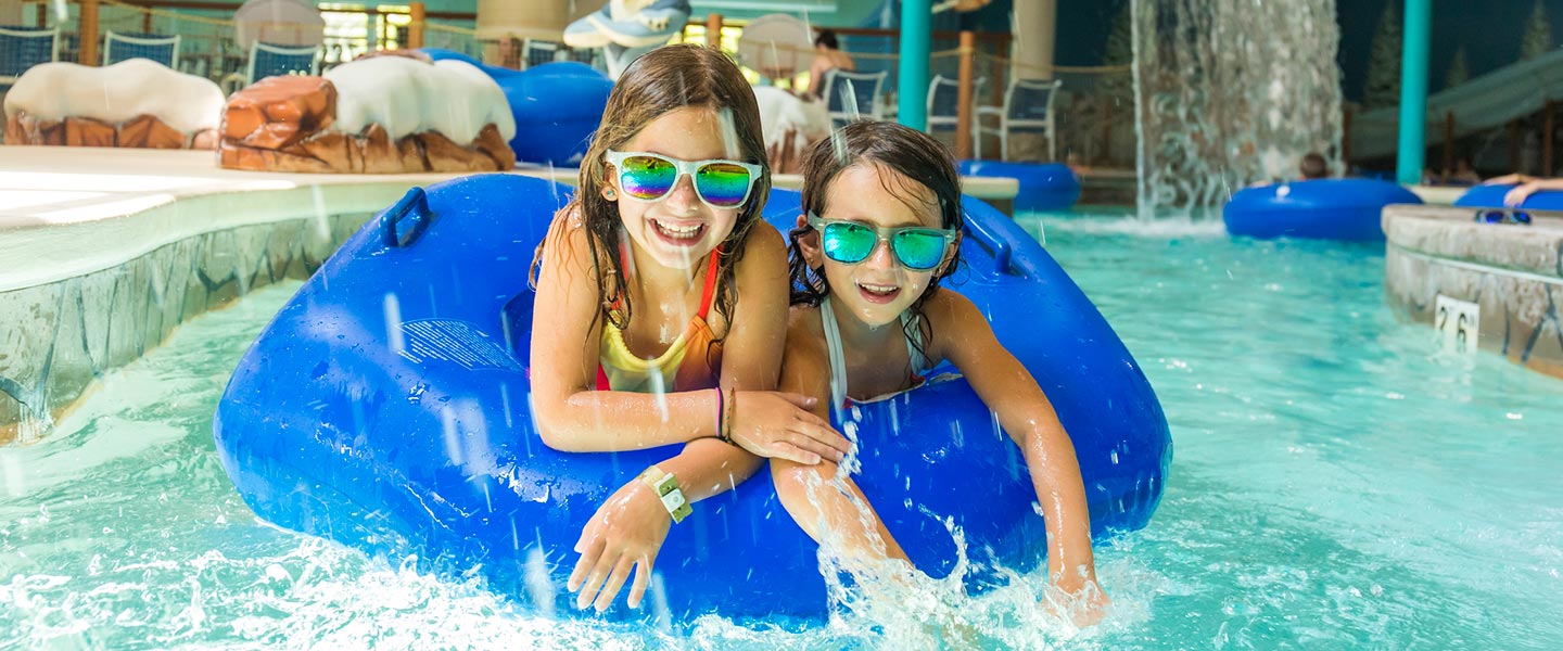 Two young girls splashing in the Lazy River at Avalanche Bay Indoor Waterpark